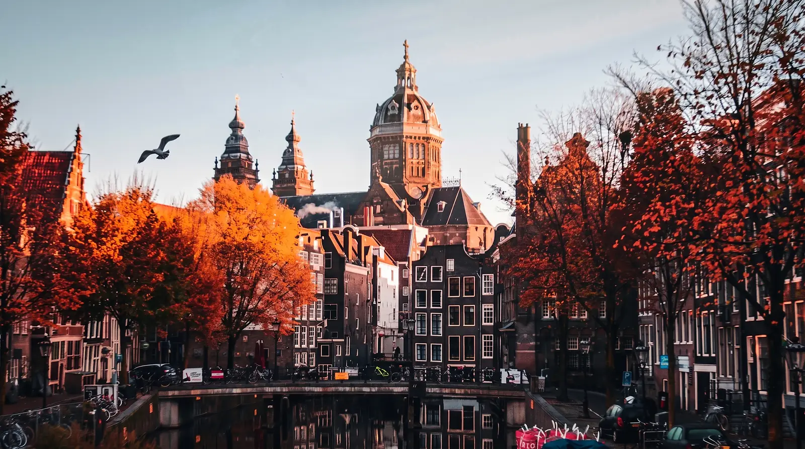 Casas junto a un canal de Ámsterdam entre árboles de otoño, Países Bajos